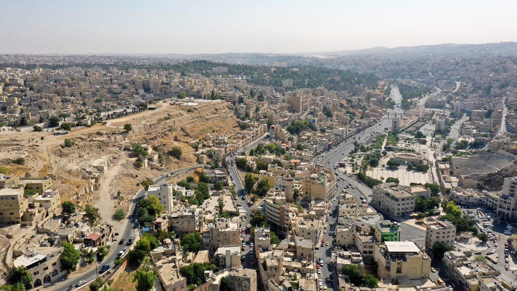 Aerial view of the southern side of the Amman Citadel (with dirt trail and ruins at left) and the Roman theater (far right). (Photo by ChickMania Entertainment, courtesy of ACOR/USAID SCHEP.)